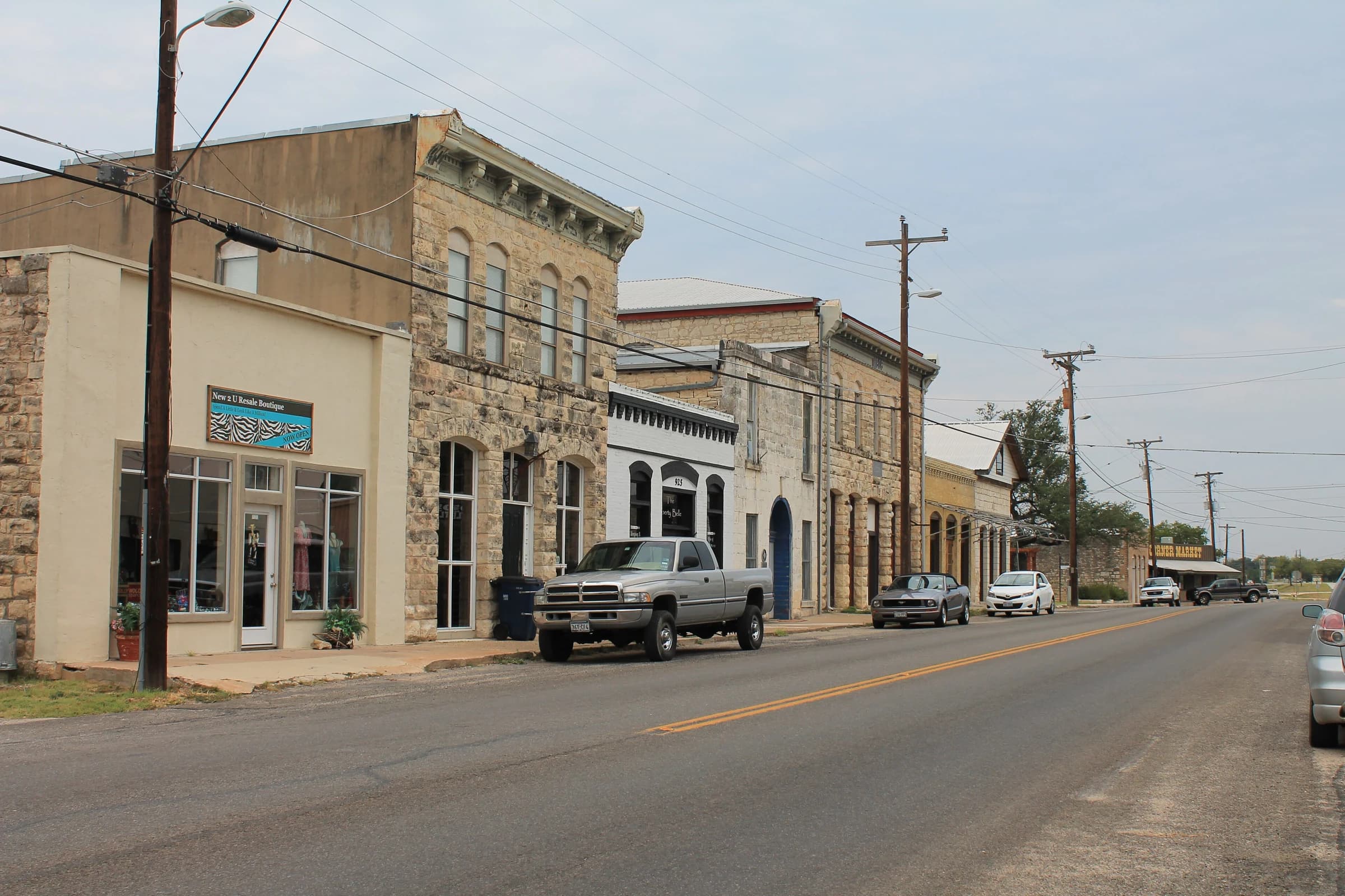 Nineteenth-century limestone commercial buildings lining the old main street of Liberty Hill, Texas, with pickups parked out front